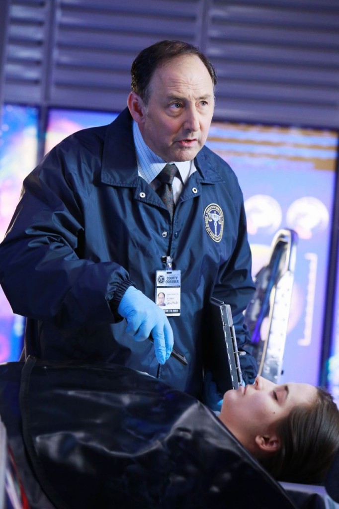 Perlmutter (Arye Gross) étudie le corps de la victime à la recherche d'indices.
