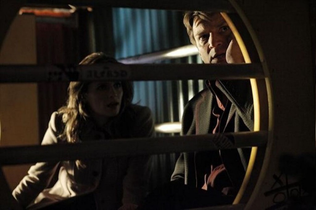 Castle (Nathan Fillion) et Beckett (Stana Katic) surveillent ce qui se passe à l'extérieur.