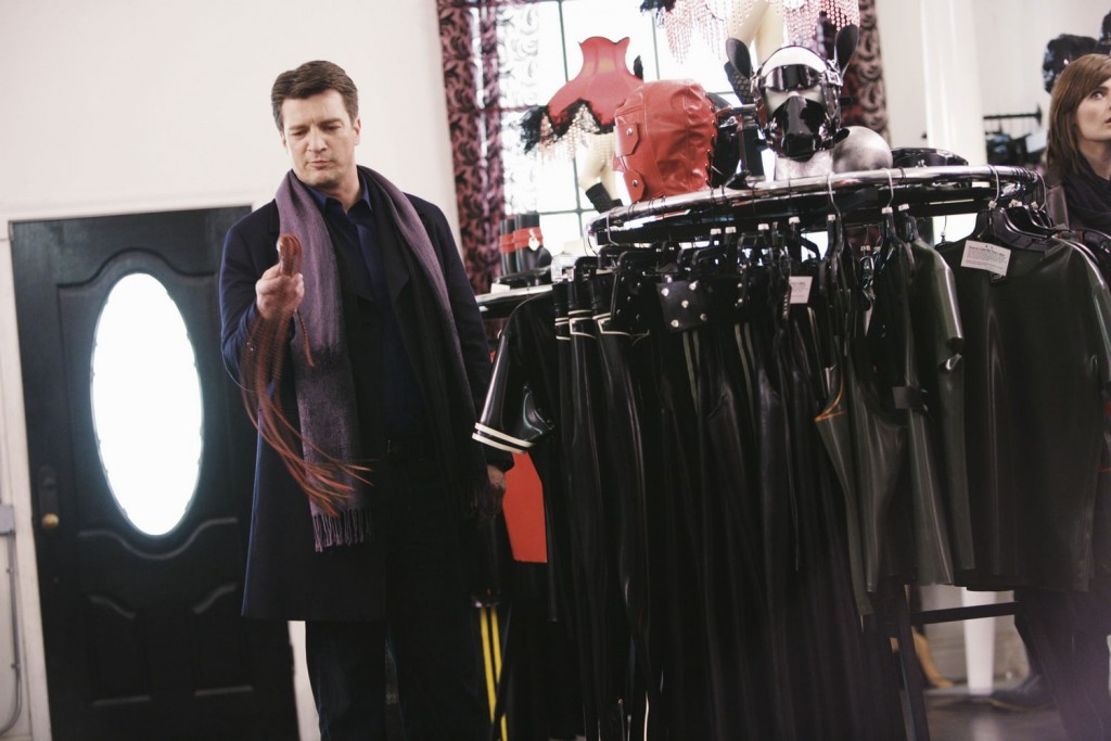 Castle (Nathan Fillion) intéressé par ses trouvailles en boutique.