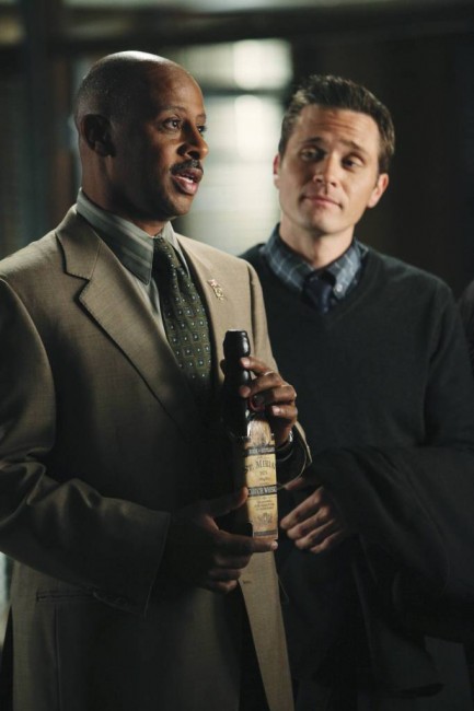 Sous le regard de Ryan, Montgomery présente une bouteille à Castle.