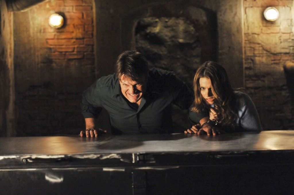 Beckett (Stana Katic) et Castle (Nathan Fillion) poussent un coffre.